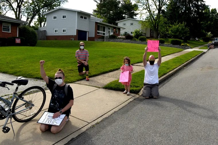 Jason Messick, 40, of Abington (with four year-old daughter takes a knee as he joins other protesters gathered outside the Plymouth Meeting home of Montgomery County Commissioner Joe Gale June 7, 2020, calling for him to resign after he called Black Lives Matter a hate group.