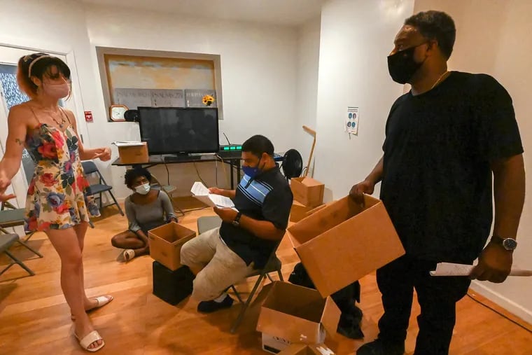 'A Thousand Fibers' co-director Sofia Anastasia (left) coaches cast member Ray Thomas, who plays Sam, (far right) during a rehearsal at Ekklesia Church in North Philadelphia, August 11, 2021. Pastor Curtis Saxton, who plays a priest named Angel,  is seated  (center), and Blahir Sargent, as  Alice, is seated  (left) on the floor.