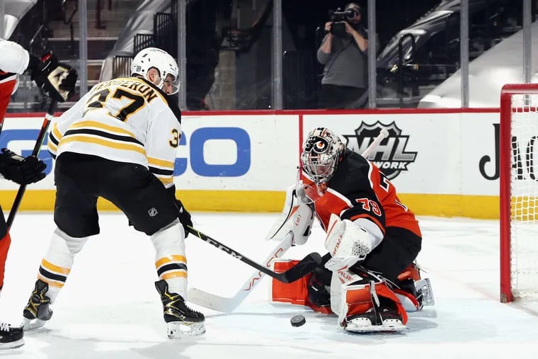 The Bruins' Patrice Bergeron scores a power-play goal 31 seconds into overtime against the Flyers' Carter Hart.