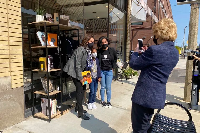 Michigan Sen. Debbie Stabenow, right, takes a picture of Vice President-elect Kamala Harris as she poses with Egypt Otis and her 9-year-old daughter Eva Allen on Sept. 22, 2020 in front of their Flint, Mich., bookstore, the Comma Bookstore & Social Hub. For countless women and girls, Harris' achievement of reaching the second-highest office in the country represents hope, validation and the shattering of a proverbial glass ceiling that has kept mostly white men perched at the top tiers of American government.