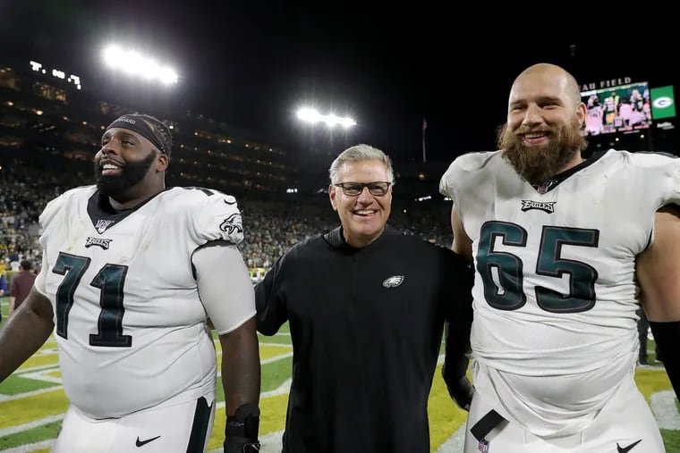 Philadelphia Eagles offensive tackle Jason Peters, left, and Philadelphia Eagles offensive tackle Lane Johnson, right, smile as the walk off the field with offensive line coach Jeff Stoutland, center, after defeating the Packers. Philadelphia Eagles win 34-27over the Green Bay Packers at Lambeau Field in Green Bay, WI on September 26, 2019.