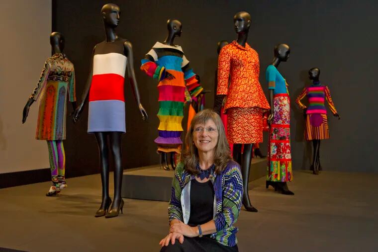Curator Kristina Haugland sits in front of a collection of dresses that explore the use of color and pattern, part of a new exhibit at the Philadelphia Museum of Art Dorrance Special Exhibition Galleries, October 5, 2018. Avi Steinhardt / For the Inquirer