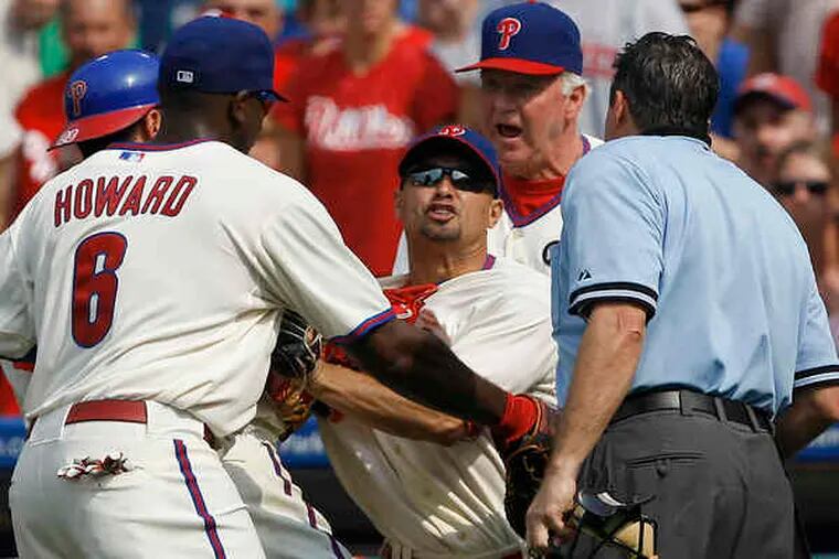 Phillies centerfielder Shane Victorino (center) is restrained after being ejected by home plate umpire Ed Rapuano in the seventh inning.