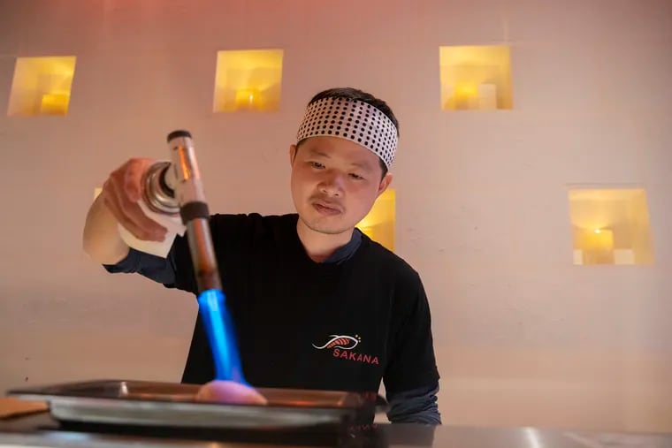 Sam Lin, owner and chef of Sakana, torches fresh fish in Queen Village. Sakana is an omakase counter that is more affordable than most omakase dining experiences.