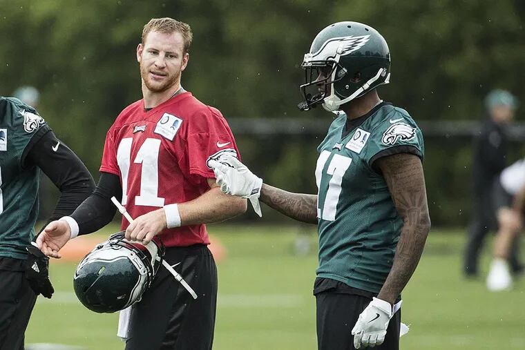 Philadelphia Eagles wide receiver Alshon Jeffery (right) talks with quarterback Carson Wentz during OTAs at the NovaCare Complex.