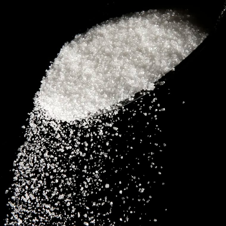 FILE - Granulated sugar is poured using a spoon, Sept. 12, 2016, in Philadelphia. New York City residents may soon see warning labels next to sugary foods and drinks in chain restaurants and coffee shops, under a law set to go into effect later in 2024. (AP Photo/Matt Rourke, File)