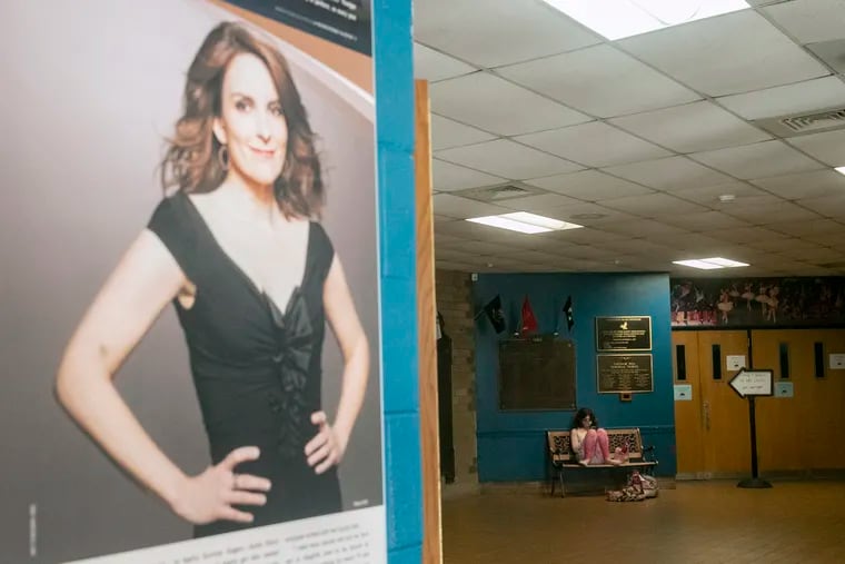 A photo of alum Tina Fey at the Upper Darby Performing Arts Center at Upper Darby High School. In the background, Upper Darby Summer Stage participants eat and rest during a break from rehearsing this year's season opener, "The Wizard of Oz."