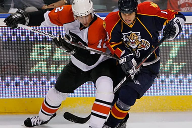 Simon Gagne and Florida Panthers center Nathan Horton battle for the puck during the first period yesterday. (AP Photo/Wilfredo Lee)