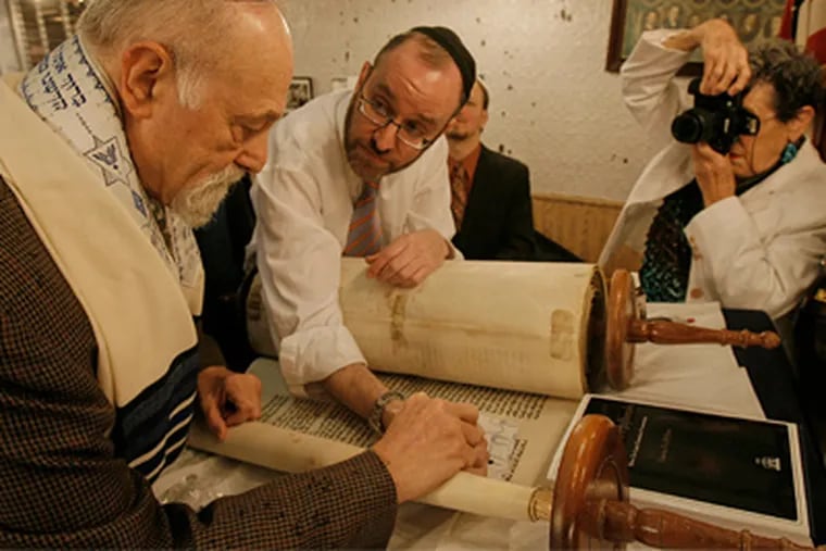 Thus it is written: Rabbi Menachem Youlus, a Torah scribe, helps Hal Rosenthal ink in a letter of Genesis at Congregation Shivtei Yeshuron Israel in South Philadelphia. Rosenthal's wife, Sue, got the moment on film. (Akira Suwa / Staff Photographer)