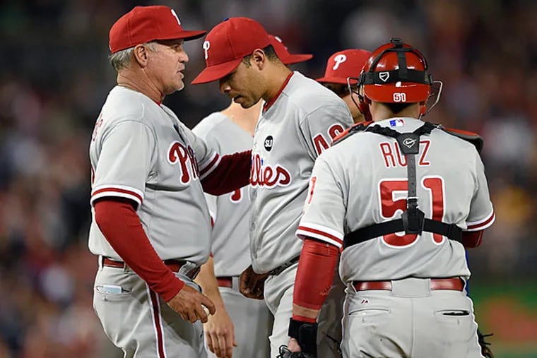 Philadelphia Phillies relief pitcher Jeanmar Gomez, center, is pulled from the game by manager Ryne Sandberg, left, during the seventh inning of a baseball game against the Washington Nationals, Friday, April 17, 2015, in Washington. Also seen is Philadelphia Phillies catcher Carlos Ruiz (51). The Nationals won 7-2. (AP Photo/Nick Wass)