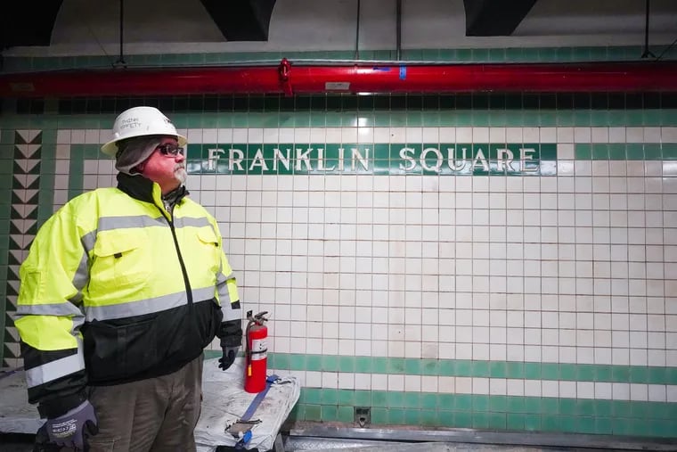 Ken Hanson, senior project manager, admires the original tile work at the Franklin Square PATCO station, which is under construction at North Seventh and Race Streets.