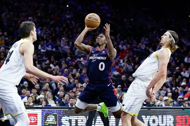 Sixers guard Tyrese Maxey shoots the basketball against Utah Jazz forward Kelly Olynyk (left) and center Walker Kessler in the fourth quarter on Saturday, January 6, 2024 in Philadelphia.