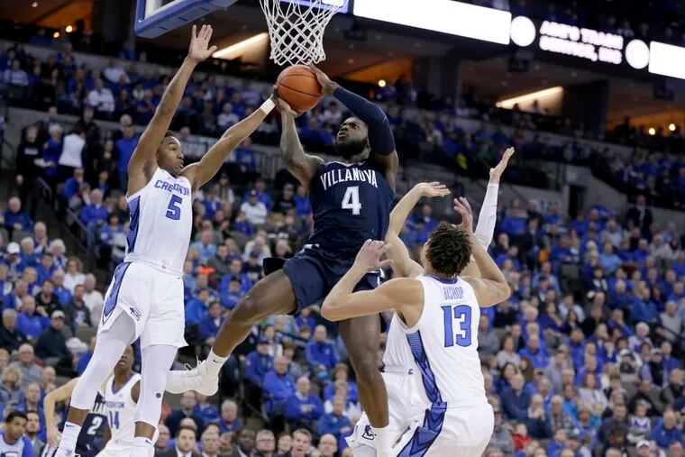 Villanova's Eric Paschall (4) goes to the basket against Creighton's Ty-Shon Alexander (5), Christian Bishop (13) and Marcus Zegarowski, rear, during the first half.