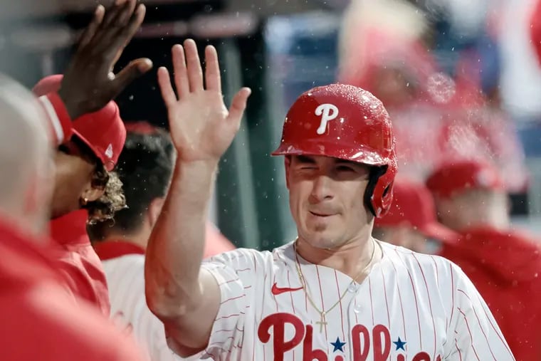 Catcher J.T. Realmuto gets high fives in the Phillies dugout after scoring a run against the San Francisco Giants on May 4.
