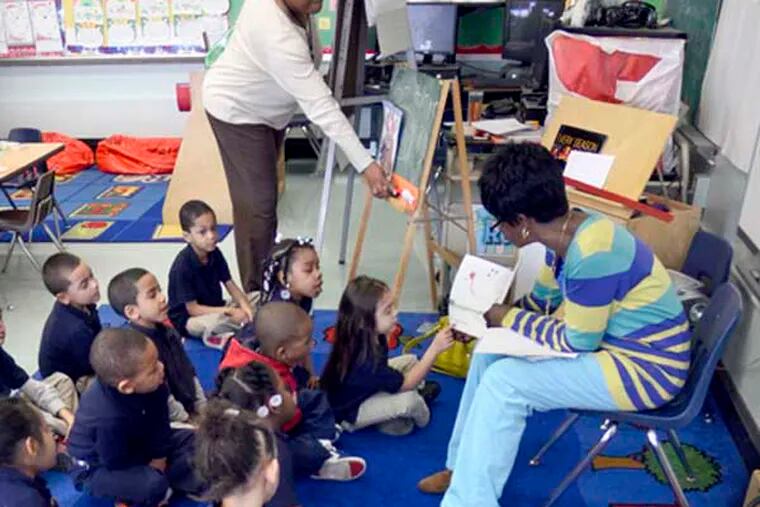 Special education teacher Ellen Hamilton (right) reads to students in kindergarten classroom of Shirley Johnson (rear) at  Cooper's Poynt School March 27, 2014. The class only has 13 students, comparable to most private schools. ( TOM GRALISH / Staff Photographer )