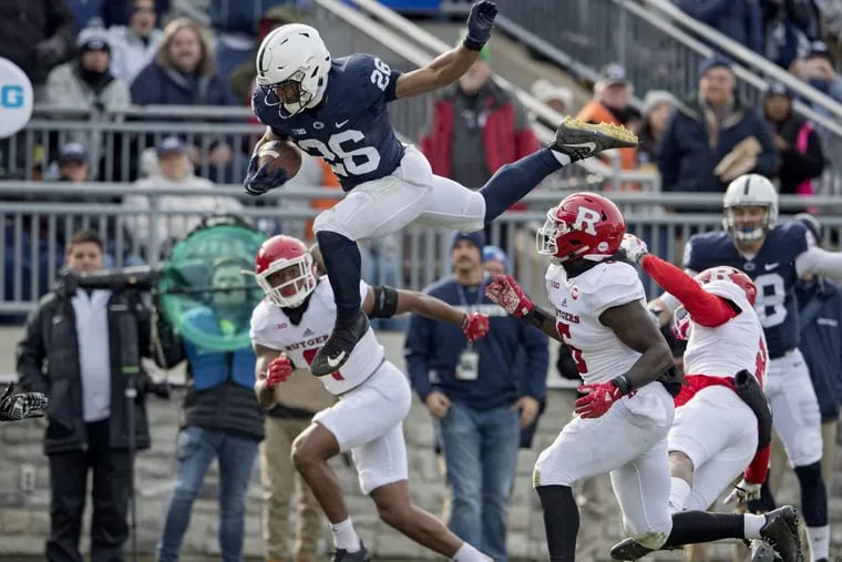 Penn State running back Saquon Barkley leaps over Rutgers defenders on Saturday.