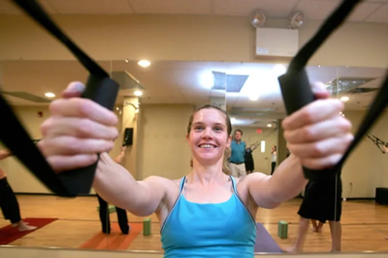 Larissa Pluta uses the aeroSling at Verge Yoga. She says it has helped her strengthen and heal an injured shoulder. (David Swanson / Staff Photographer)