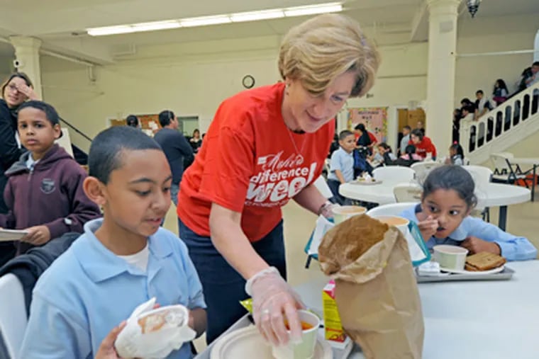 Denise Morrison serves soup to Vincent Lopez and Sienna Castro, both 9, at Holy Name School in North Camden. (April Saul / Staff Photographer)