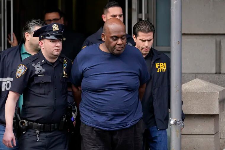 New York City Police and law enforcement officials led subway shooting suspect Frank James, center, away from a police station, in New York on April 13.