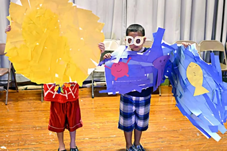 Lance Worley (left) and Arturo Sequeira portray the sun and the sea during a rehearsal for a performance of &quot;Surfin' USA&quot; in the summer program in Bucks County. TOM GRALISH / Staff Photographer