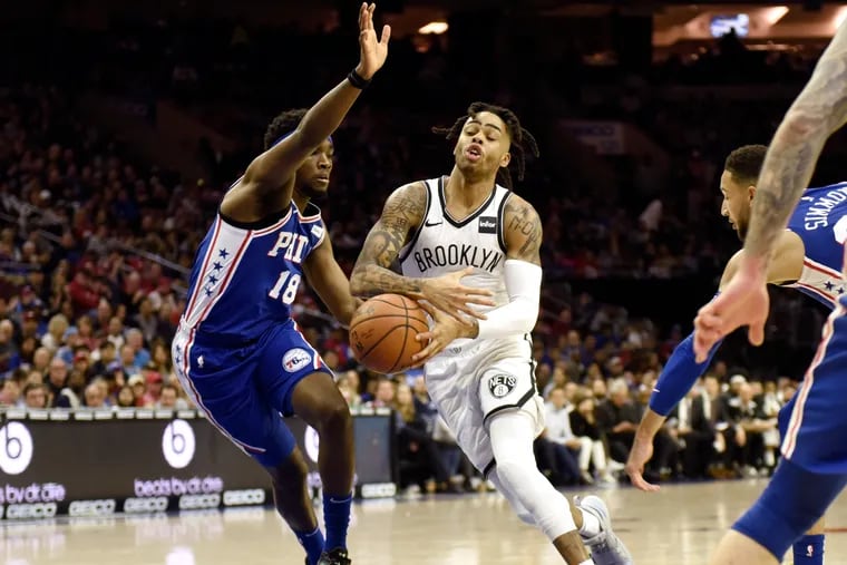 Brooklyn Nets' D'Angelo Russell, center right, drives to the basket as Philadelphia 76ers' Shake Milton defends during the first half of an NBA basketball game, Thursday, March 28, 2019, in Philadelphia. (AP Photo/Michael Perez)