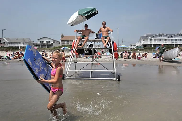 Lifeguards Blake Trabuchi-Downey, left, of Vineland, and Doug Nowak, of West Chester, watch swimmers from the new, aluminum lifeguard chair at the ocean's edge in Sea Isle City. The Sea Isle City Beach Patrol celebrates its centennial next week.