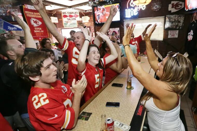 Bartender Laura Galdo high fives Chiefs fans at the bar in the closing seconds of the Eagles at Kansas City Chiefs football game at Big Charlie's Saloon in South Phila. on September 17, 2017.