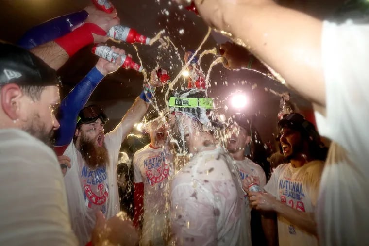 Philadelphia Phillies designated hitter Bryce Harper (center) is showered with beer in the clubhouse. Phillies win 4-3 over the San Diego Padres in game five of the National League Championship Series at Citizen Bank Park in Philadelphia, Pa. on Sunday, Oct. 23, 2022. Phillies are the National League champs and move on to the World Series