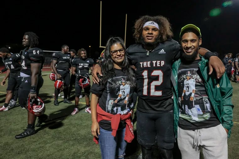 Imhotep Charter quarterback Mikal Davis Jr. poses with his mother, Candace Campbell, and his older brother, Rae’Quan Williams, on Sept. 15.