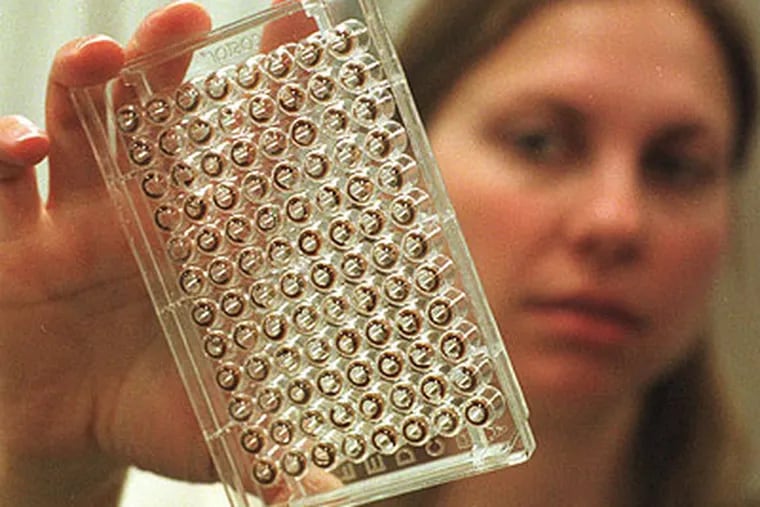 A researcher holds a tray of human DNA that is undergoing the sequencing process. Scientists at Johns Hopkins say such mapping is not yet of use for everyone. (AP Photo/Patricia McDonnell)