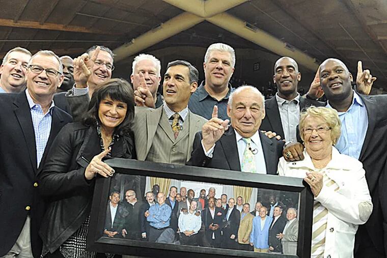 Former 'Nova players surround current coach Jay Wright (front center) and former coach Rollie Massimino (front, second from right). Front row (L-R): R.C. Massimino, Patty Wright, wife of Jay Wright, Rollie Massimino and wife Mary Jane Massimino. Back row: Dwayne McClain, Harold Pressley, Chuck Everson, Wyatt Maker, Mark Plansky, Brian Harrington, Connally Brown, Steve Pinone. (Clem Murray/Staff Photographer)