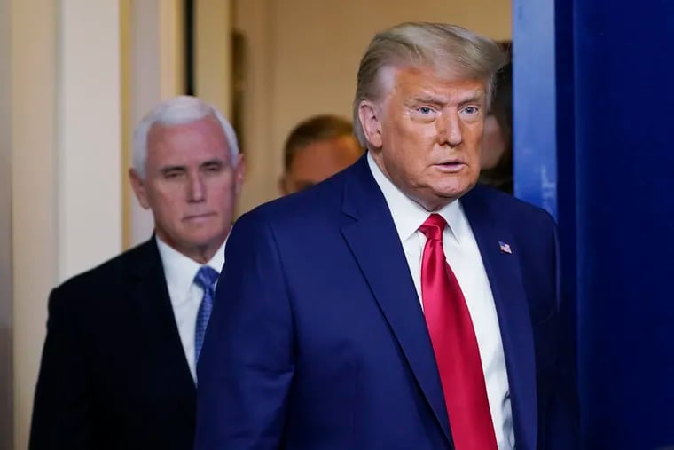 President Donald Trump walks out to speak in the Brady Briefing Room in the White House on Tuesday in Washington as Vice President Mike Pence looks on.