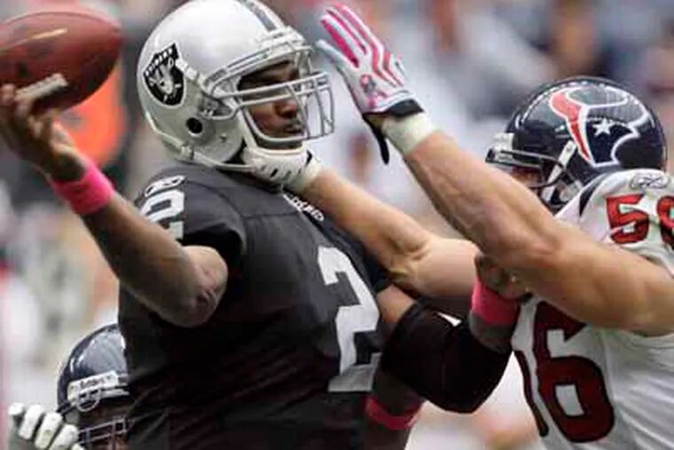 Houston Texans linebacker Brian Cushing (56) pressures Oakland Raiders quarterback JaMarcus Russell (2) during the third quarter of a NFL football game Sunday, Oct. 4, 2009 in Houston. (AP Photo/David J. Phillip)