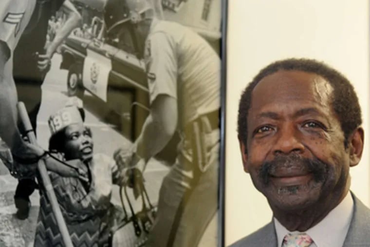 Henry Nicholas stands by a photo of striking hospital workers in Charleston, S.C., in 1969.