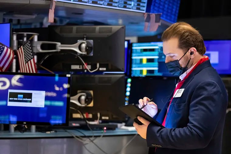 In this photo provided by the New York Stock Exchange, trader Ben Tuchman works on the floor on Jan. 28, 2022. Stock prices have been on a tear, rising close to 30% last year alone.   (Allie Joseph/New York Stock Exchange via AP)
