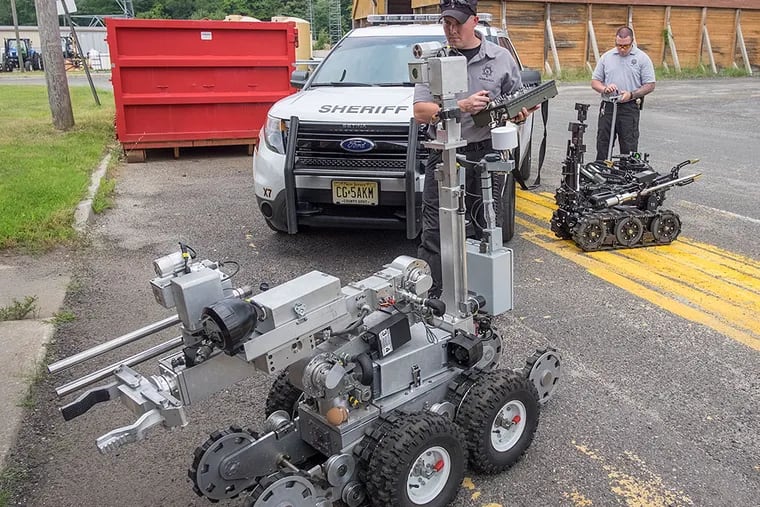 Joseph Welsh (left) and Neil Thorp, of the Camden County Sheriff’s Office bomb unit, with their robotic charges. ED HILLE / Staff Photographer