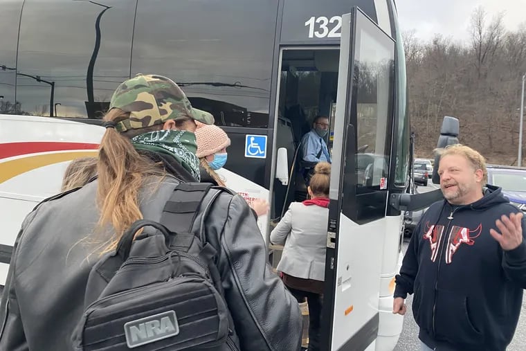 Ben Philips greets people as they board a bus bound for Washington Jan. 6, 2021.