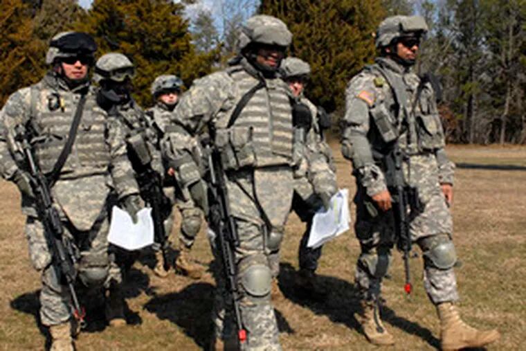 After a five-mile walk in the woods, Army Reservists head back to their base at Fort Dix. Philadelphia Police Officer William Phillips (far right) said his work in the city has prepared him well for teaching community policing in Iraq.