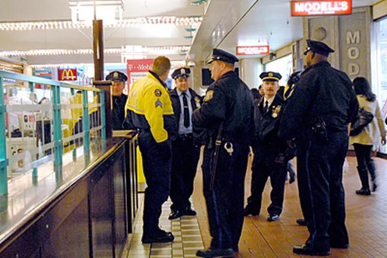 Officers patrol at the Gallery last month, one day after about 150 teens spilled out of the mall, rampaged through Macy's and knocked down pedestrians. ( April Saul / Staff / File)
