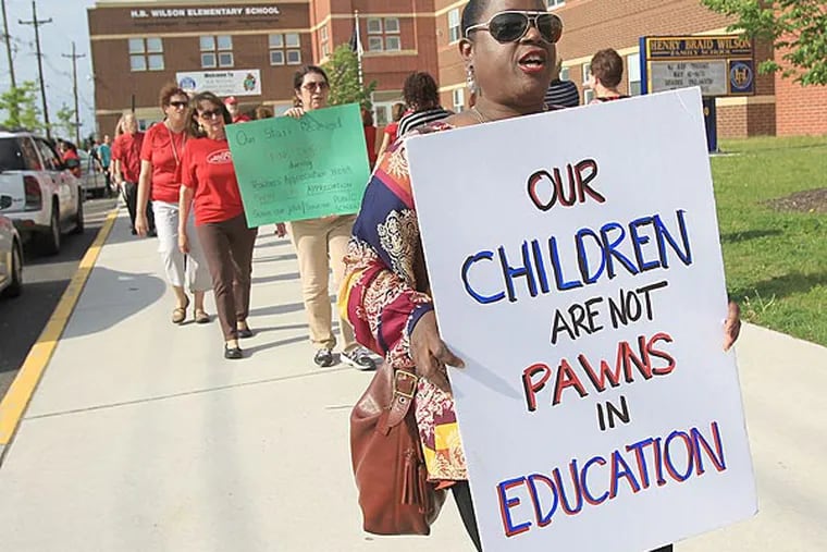 File photo: Debbie Flores, a kindergarten teacher at Sharp Elementary, and other teachers carry signs outside of H.B. Wilson Elementary School over possible job layoffs.  ( CHARLES FOX / Staff Photographer /May 12, 2014)