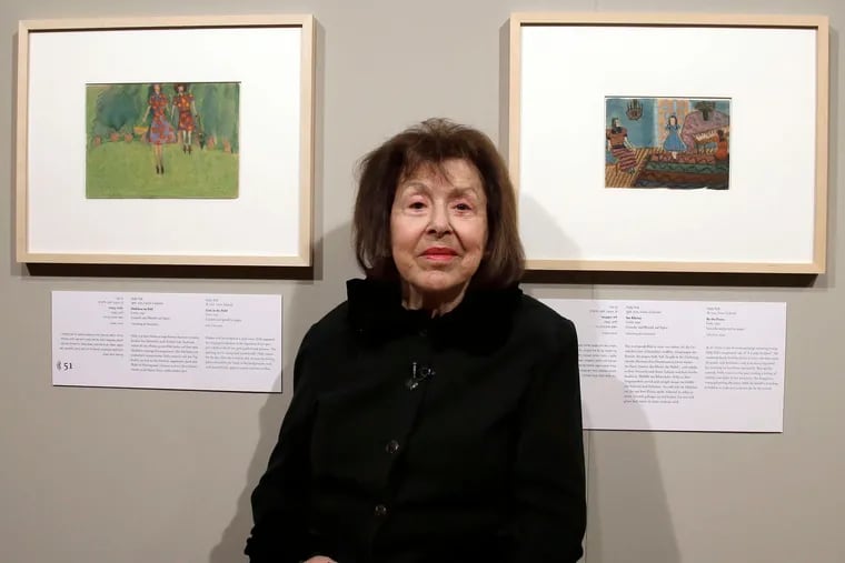Dr. Toll stands between two of her paintings at a display of Holocaust art in Berlin in 2016.