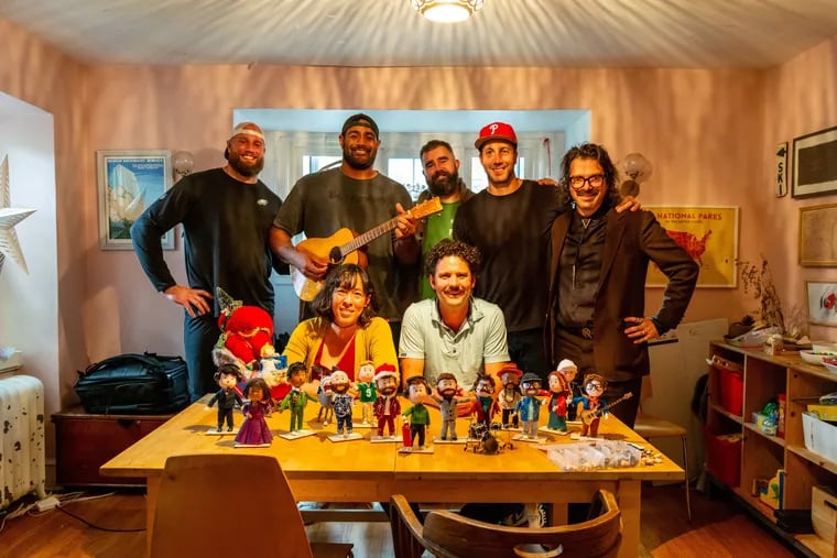 Eagles linemen Lane Johnson (from left), Jordan Mailata, and Jason Kelce and "A Philly Special Christmas Special" executive producer Connor Barwin and producer Charlie Hall standing with unPOP animation studio cofounders Marie Hart and Peter Heacock and the figurines they created for the "A Philly Special Christmas Special" short film. It premieres on YouTube at 8 p.m. on Thanksgiving.
