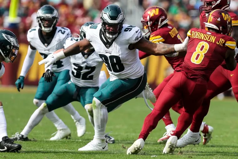 Eagles defensive tackle Jalen Carter grabs Commanders running back Brian Robinson in the second quarter Sunday at FedEx Field.