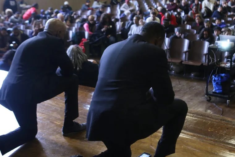 Reverend Greg Holston, Executive Director of POWER, and Reverend Jay Broadnax, President of the Black Clergy of Philadelphia and Vicinity, Inc. kneel alongside hundreds others on MLK Jr. Day. to honor former NFL player and social justice activist Colin Kaepernick.
