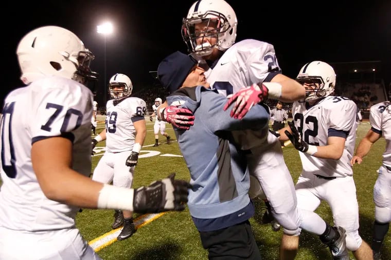 Shawnee's David Smith is swarmed by teammates after an interception. (Ron Cortes/Staff Photographer)