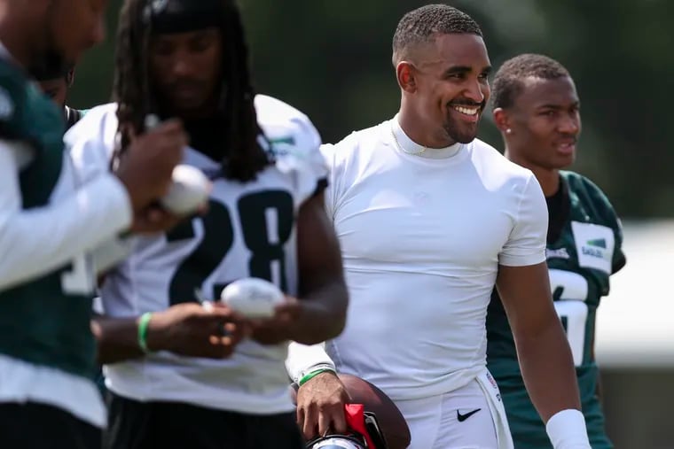 Eagles quarterback Jalen Hurts (center) smiles to fans on the first day of training camp.