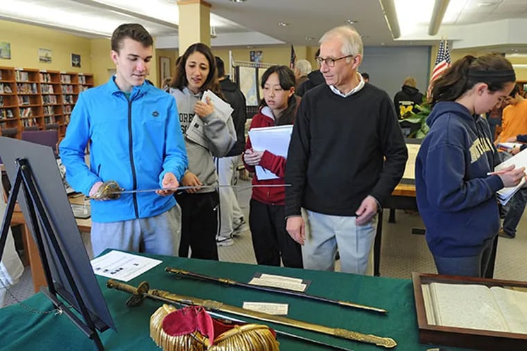 Lenny Wagner, right, president of the Historical Society of Moorestown, watches as Ryan Zimmer, left, Moorestown High School sophomore, handles the scabbard of Lt. Col. T.L. England at Moorestown High School, on Friday, Feb. 28, 2014. (Clem Murray / Staff Photographer)