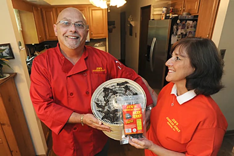 At their Medford, N.J. home, James Ewen and his wife, Joette, who make Jim's Jarhead Jerky. James holds jerky that's being processed. (April Saul/Staff)