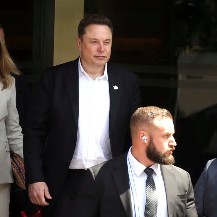 Elon Musk (center) arrives for the 10th World Water Forum in Nusa Dua, Bali, Indonesia, on May 20. A group of Tesla shareholders are asking investors to vote against a compensation package worth more than $50 billion for CEO Elon Musk, saying that it's not in the electric vehicle maker's best interest.