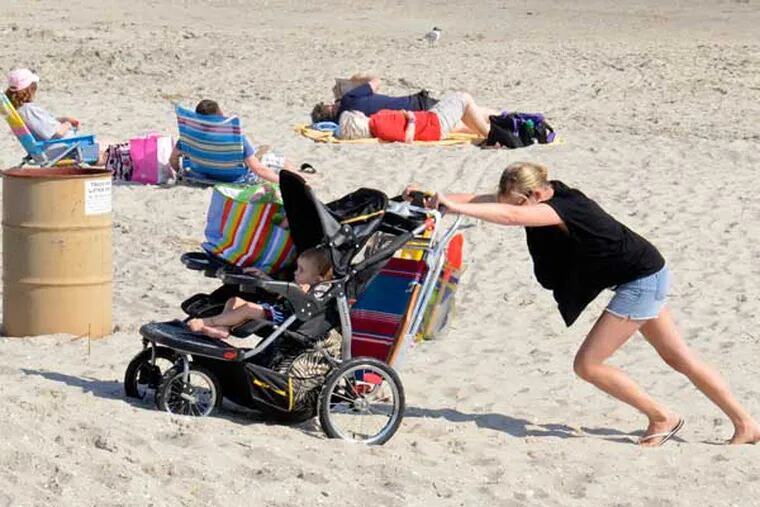 File photo: Jamie Finn of Atco pushes son 2-1/2 year old son Wes up off the beach after spending the day in Ocean City on their third day trip to the shore during an unseasonably warm week in April. TOM GRALISH / Staff Photographer )